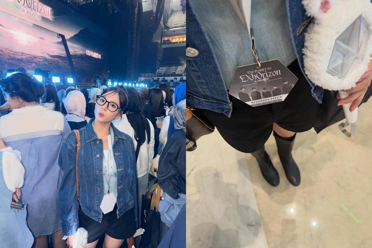 Seorang perempuan mengenakan jaket denim dan kacamata menghadiri konser EXO PLANET #6 EXhOrizon di Jakarta dengan kartu soundcheck di lehernya.