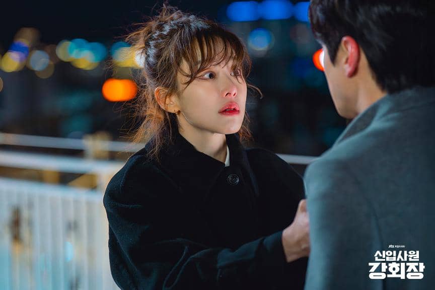 Seorang wanita menatap pria dengan ekspresi emosional di malam hari di jembatan, adegan dari drama Korea Reborn Rookie.