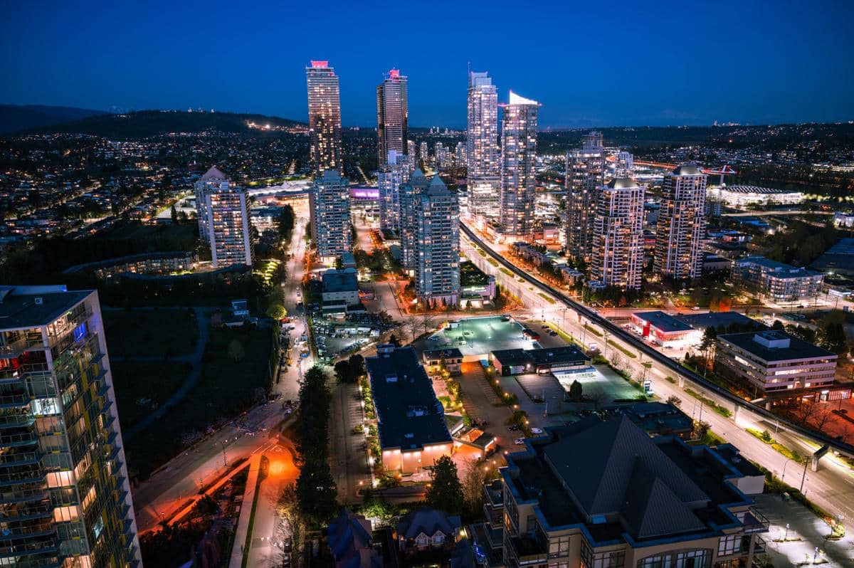 Pemandangan malam kota Burnaby di Kanada dengan gedung pencakar langit bercahaya dan jalanan yang dipenuhi lampu kota.