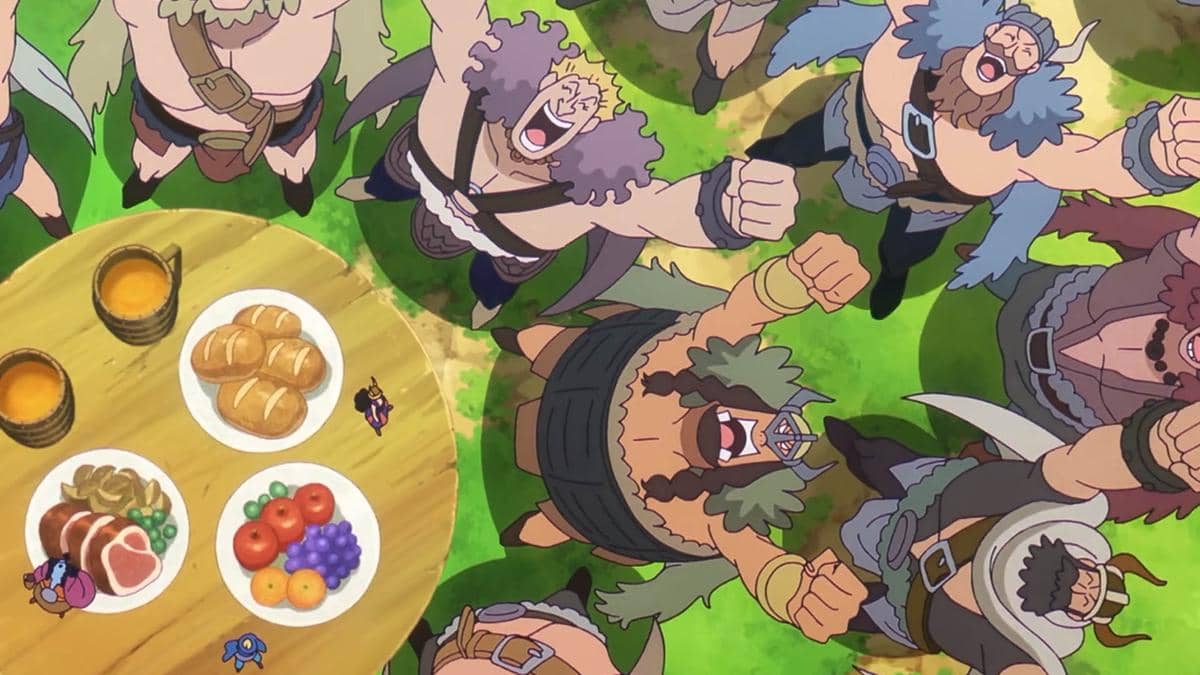Para raksasa berotot bersorak gembira di sekitar meja kayu berisi makanan dan minuman, dengan Usopp berdiri di tengah mereka.