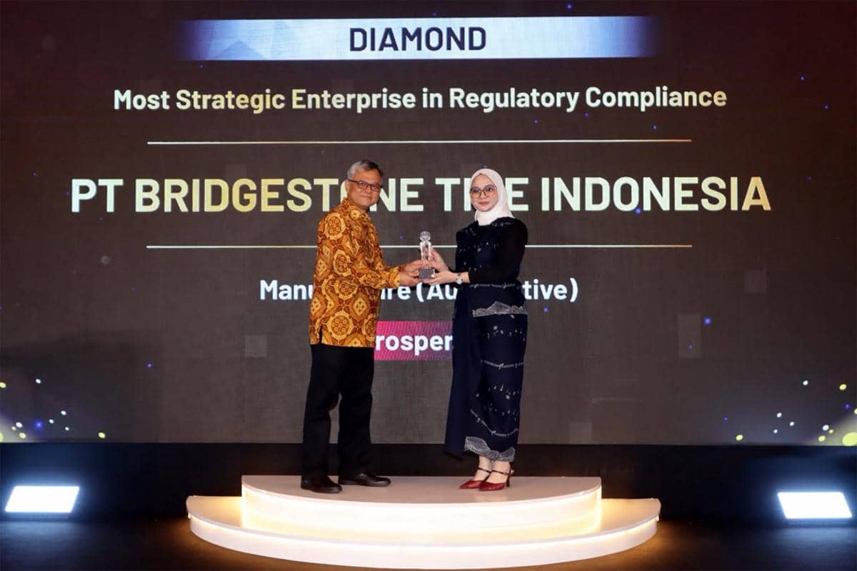 Perwakilan Bridgestone Indonesia menerima penghargaan IRCA 2026 kategori Most Strategic Enterprise in Regulatory Compliance di atas panggung.