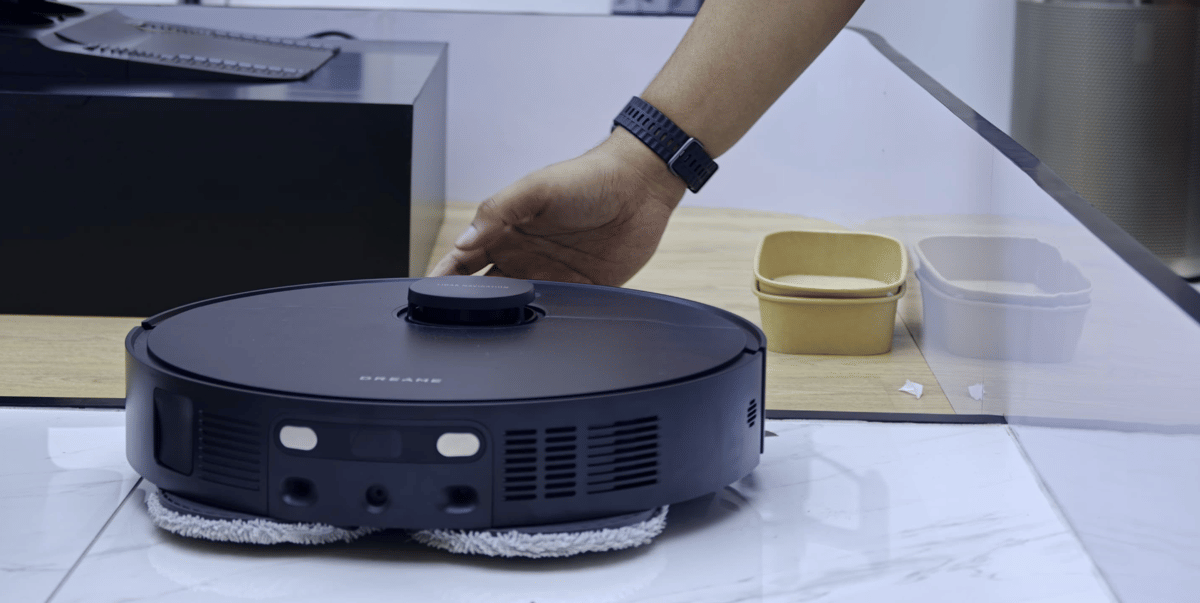 Seseorang menyentuh robot vacuum hitam Dreame yang sedang dipamerkan di acara Dreame Home Innovation Launch di Jakarta.