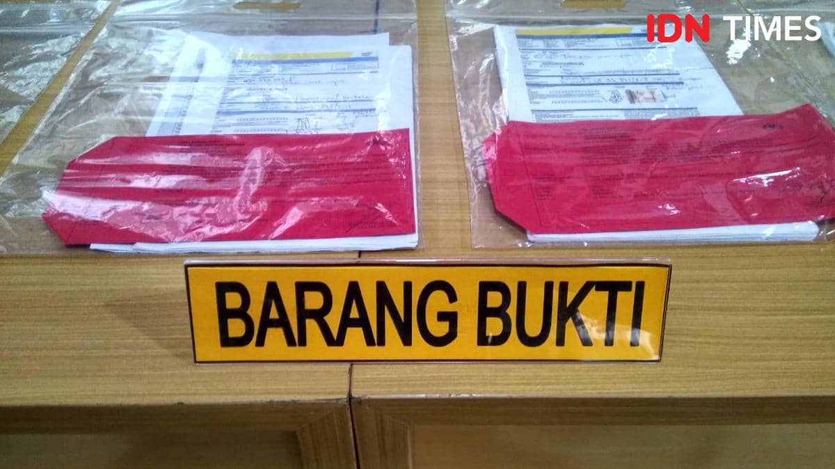 Dokumen dan berkas yang disegel dalam plastik transparan dengan label barang bukti di atas meja kayu di kantor polisi.