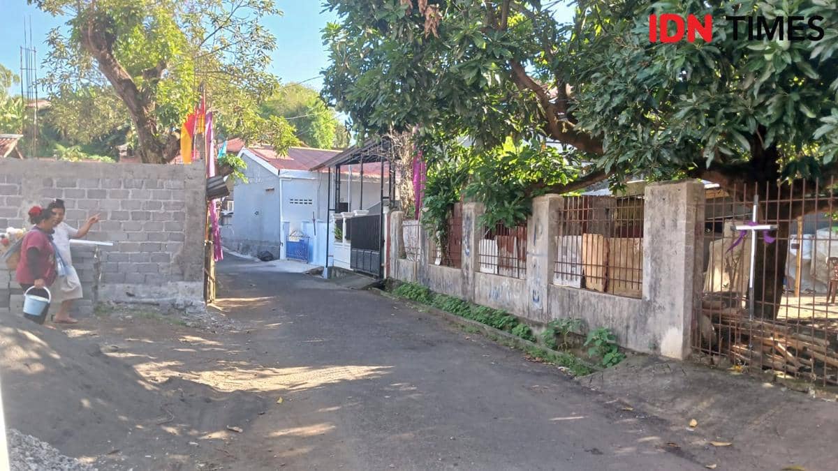 Warga berjalan di jalan kecil perkampungan Kota Manado, Sulawesi Utara, dengan rumah dan pepohonan di sekitarnya saat gempa terjadi.