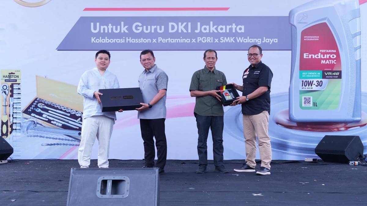 Empat pria berpose di atas panggung acara kolaborasi Hasston, Pertamina, PGRI, dan SMK Walang Jaya untuk guru DKI Jakarta.