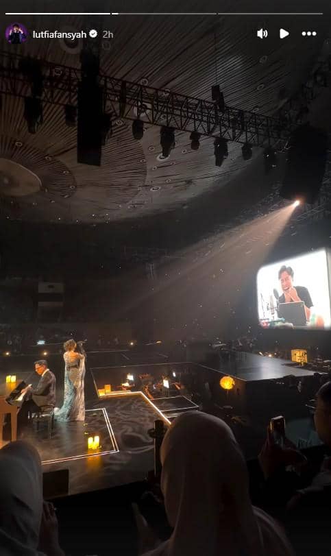 Penyanyi tampil di atas panggung bersama pianis dalam konser bertema Love & Let Go 2026 dengan pencahayaan hangat dan layar besar di belakang.