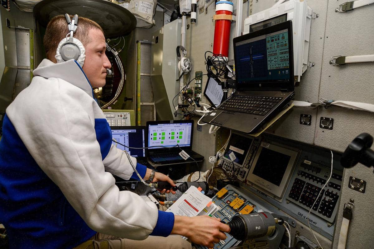 ilustrasi astronaut merawat sistem docking dengan komputer
