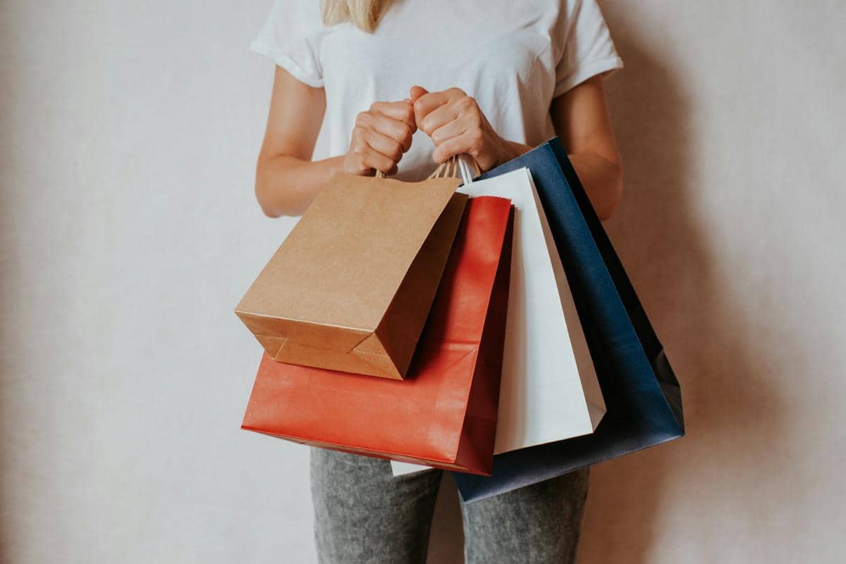 Wanita memegang tas belanja