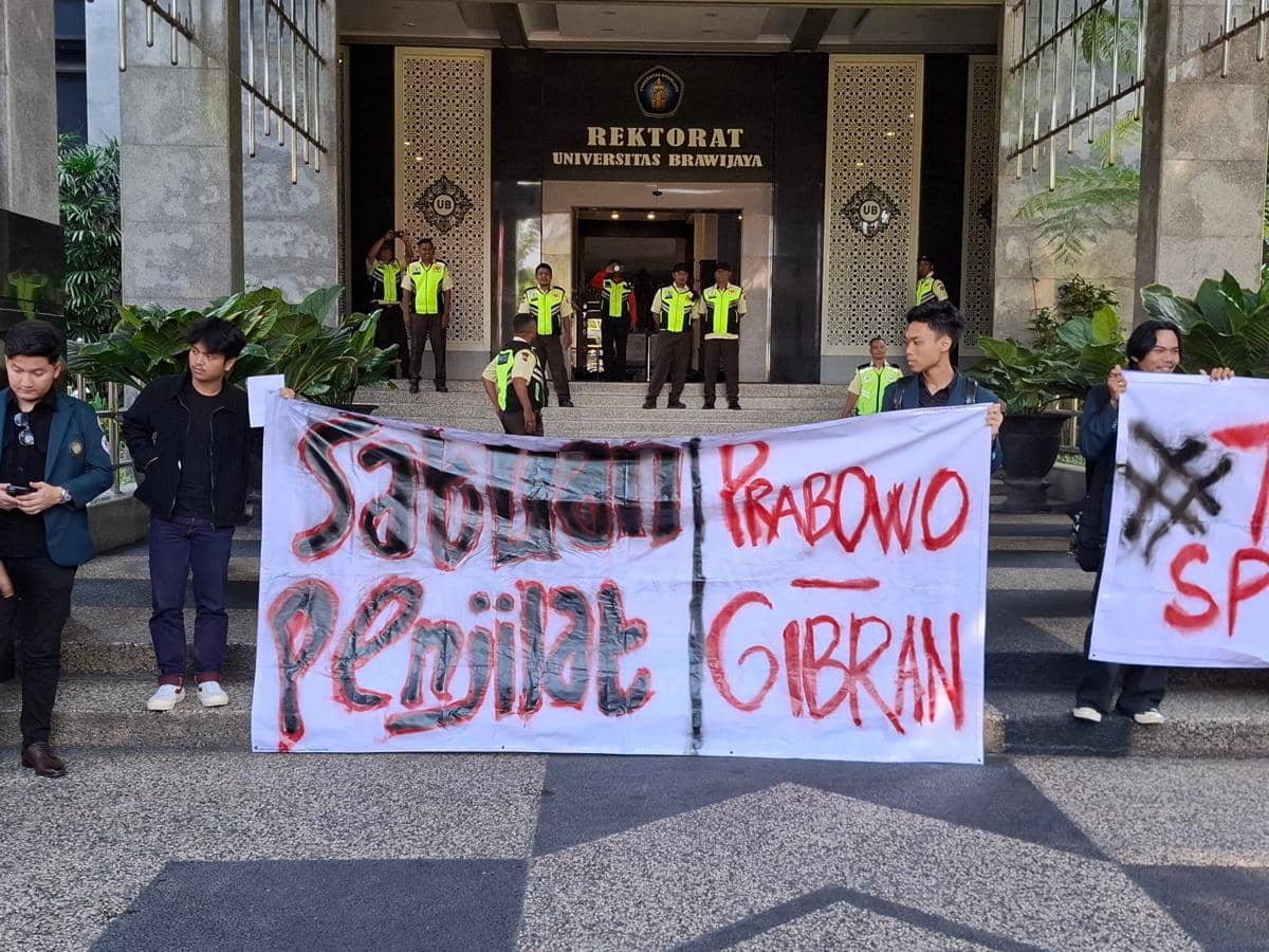 Mahasiswa Universitas Brawijaya membentangkan spanduk protes menolak SPPG di depan Gedung Rektorat UB dengan petugas keamanan berjaga.