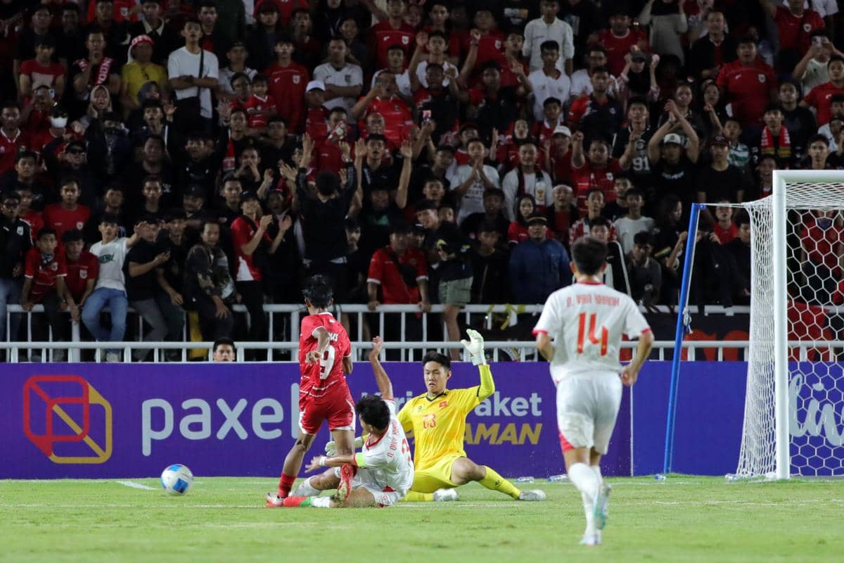 Striker timnas U-19 Indonesia berusaha mencetak gol ke gawang Vietnam U-19 di Stadion Utama Sumut dengan dukungan suporter di tribun.