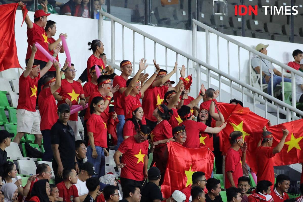 Suporter Vietnam mengenakan kaus merah dengan bintang kuning dan membawa bendera saat mendukung timnya di Stadion Utama Sumut.