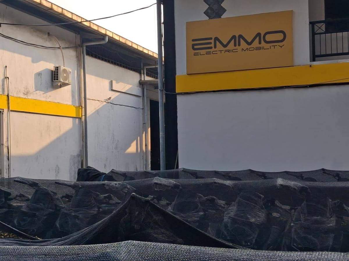 Gudang penyimpanan motor listrik EMMO di kawasan industri Sentul Bogor dengan logo perusahaan terpampang di dinding bangunan.