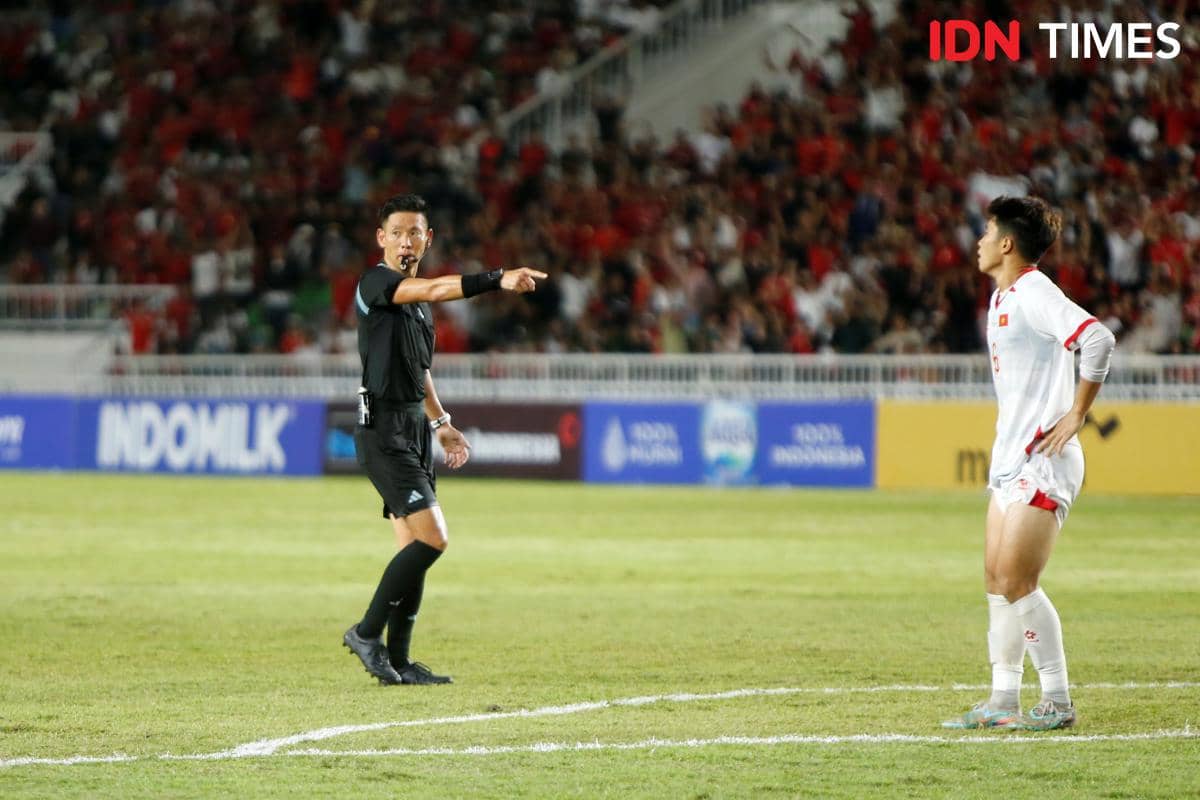 Wasit asal Jepang memimpin pertandingan Indonesia U-19 melawan Vietnam di Stadion Utama Sumut dengan latar penonton yang memenuhi tribun.