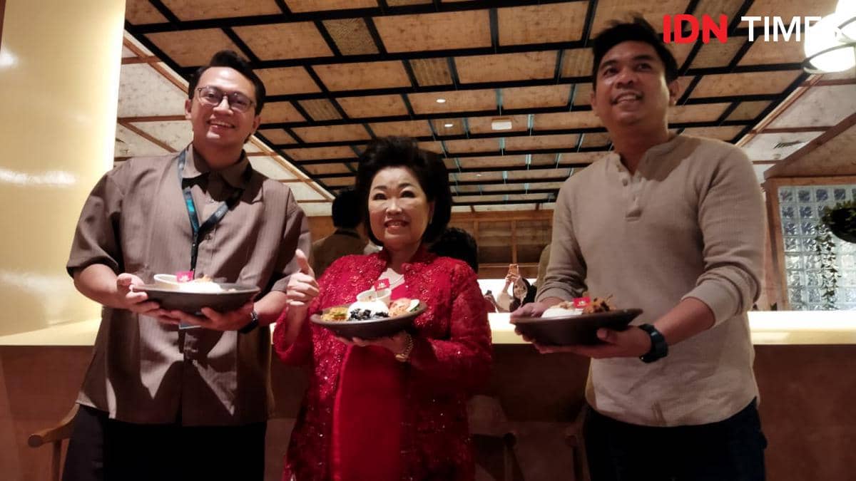 Tiga orang berpose sambil memegang piring berisi hidangan khas Jawa Timur hasil kolaborasi The People's dan Sambal Bu Rudy di sebuah restoran.