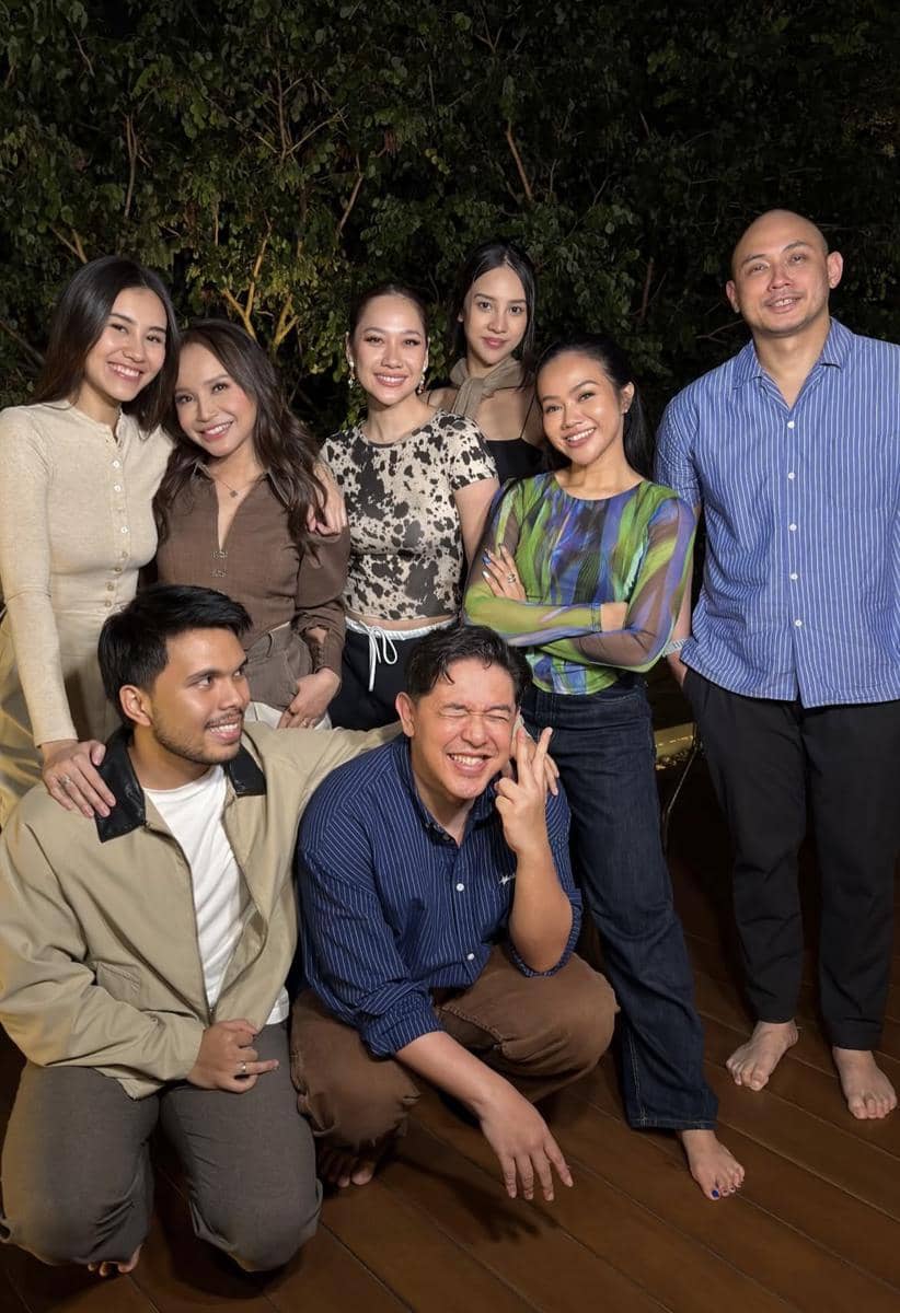 Sekelompok teman berpose bersama di malam hari di area outdoor dengan latar pepohonan, mengenakan pakaian kasual dan tersenyum ceria.