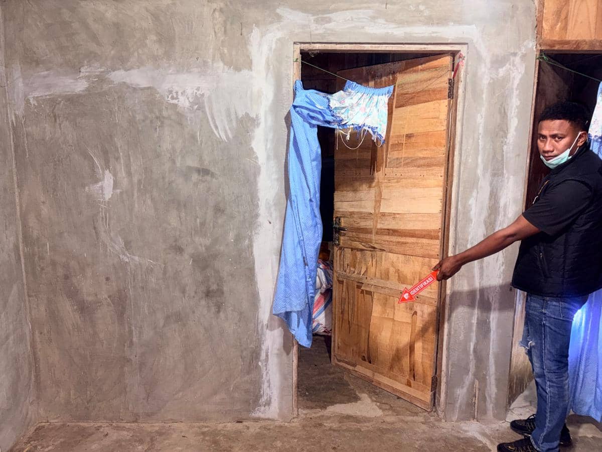 Petugas Polres Sabu Raijua melakukan olah TKP di sebuah rumah dengan dinding semen dan pintu kayu yang sebagian terbuka.