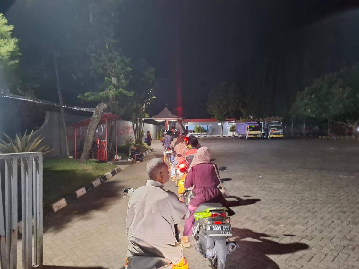 Pengendara motor mengantre untuk mengisi BBM jenis Pertalite di SPBU Pertamina Pagelaran, Kabupaten Malang pada malam hari.