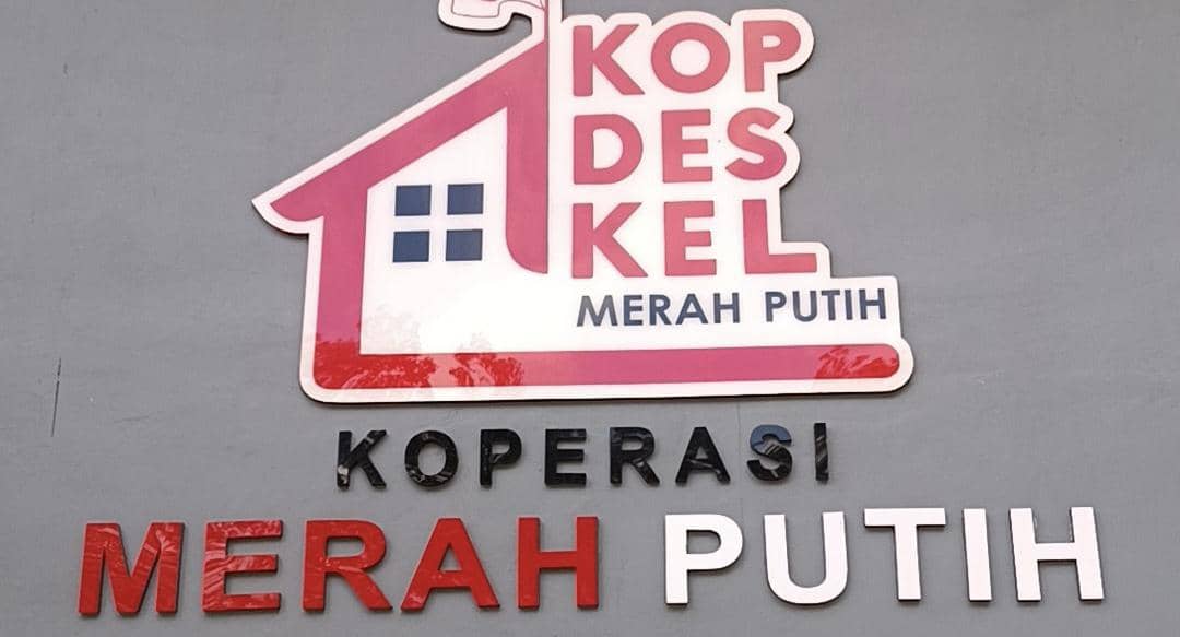Logo Koperasi Desa Kelurahan Merah Putih di Kabupaten Kupang dengan desain rumah berwarna merah dan putih di dinding abu-abu.