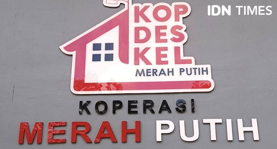 Logo Koperasi Desa Kelurahan Merah Putih di Kabupaten Kupang dengan desain rumah berwarna merah dan putih di dinding abu-abu.