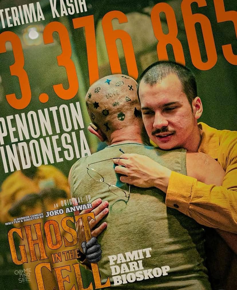 Dua pria berpelukan dengan latar tulisan besar berwarna oranye yang menampilkan judul film Ghost in the Cell dan jumlah penonton di Indonesia.