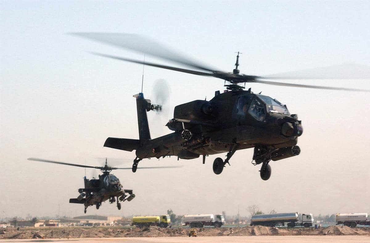 Helikopter AH-64 Apache milik militer Amerika Serikat sedang terbang di udara.