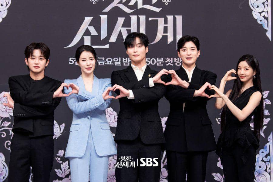 Para pemeran drama Korea My Royal Nemesis berpose bersama di acara promosi SBS, mengenakan busana formal dengan latar hitam elegan.