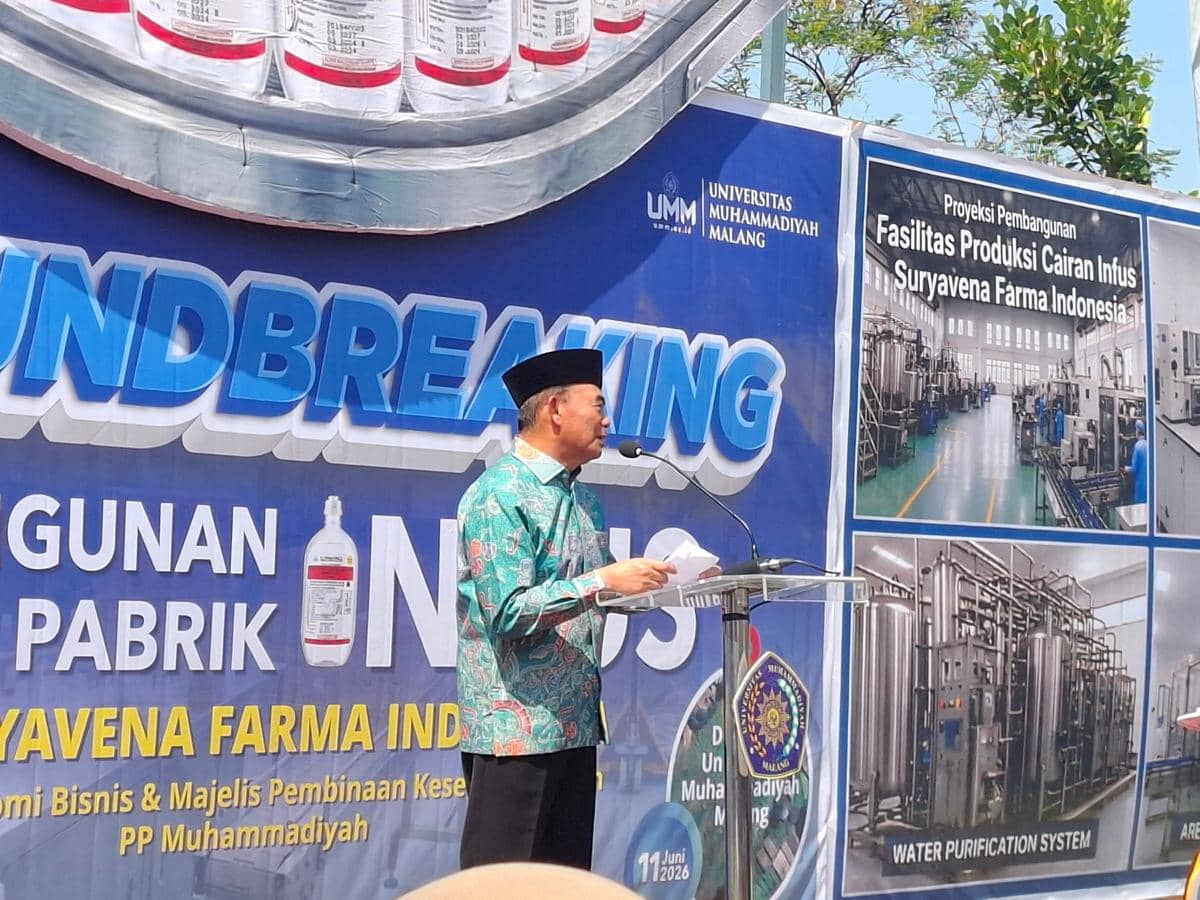 Seorang pria berbatik hijau dengan peci hitam berpidato di podium pada acara peletakan batu pertama pembangunan pabrik infus di Universitas Muhammadiyah Malang.