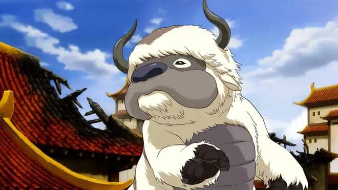 Appa, hewan terbang berbulu putih dengan enam kaki dan tanduk, berada di antara bangunan bergaya Asia dalam adegan animasi Avatar: The Last Airbender.
