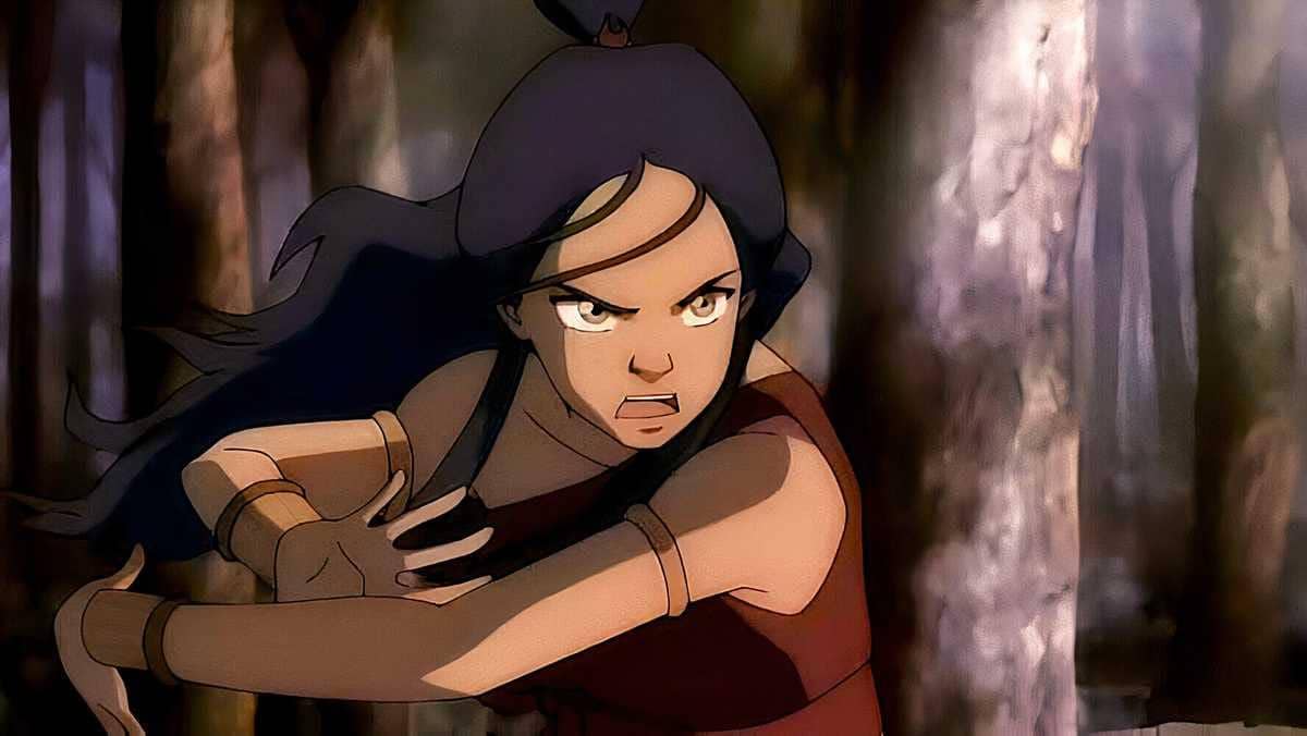Katara dari serial animasi Avatar: The Last Airbender sedang berlatih teknik Bloodbending dengan ekspresi serius di tengah hutan.