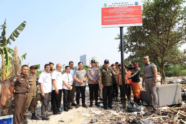 Sejumlah petugas Pemkot Tangerang bersama aparat kepolisian berdiri di area TPS ilegal di Pinang yang telah disegel dengan papan larangan.