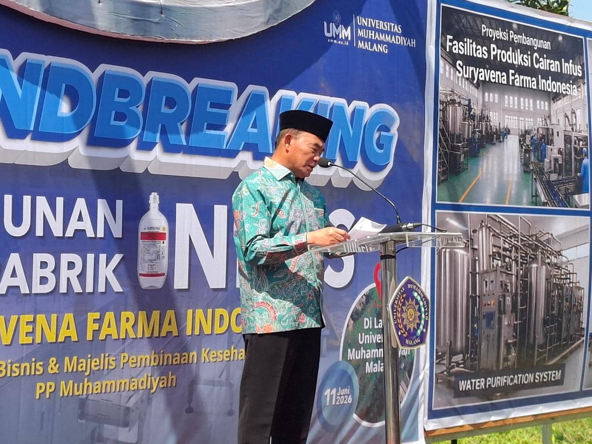 Seorang pria mengenakan batik hijau dan peci hitam berpidato di podium pada acara peletakan batu pertama pembangunan pabrik infus di Universitas Muhammadiyah Malang.