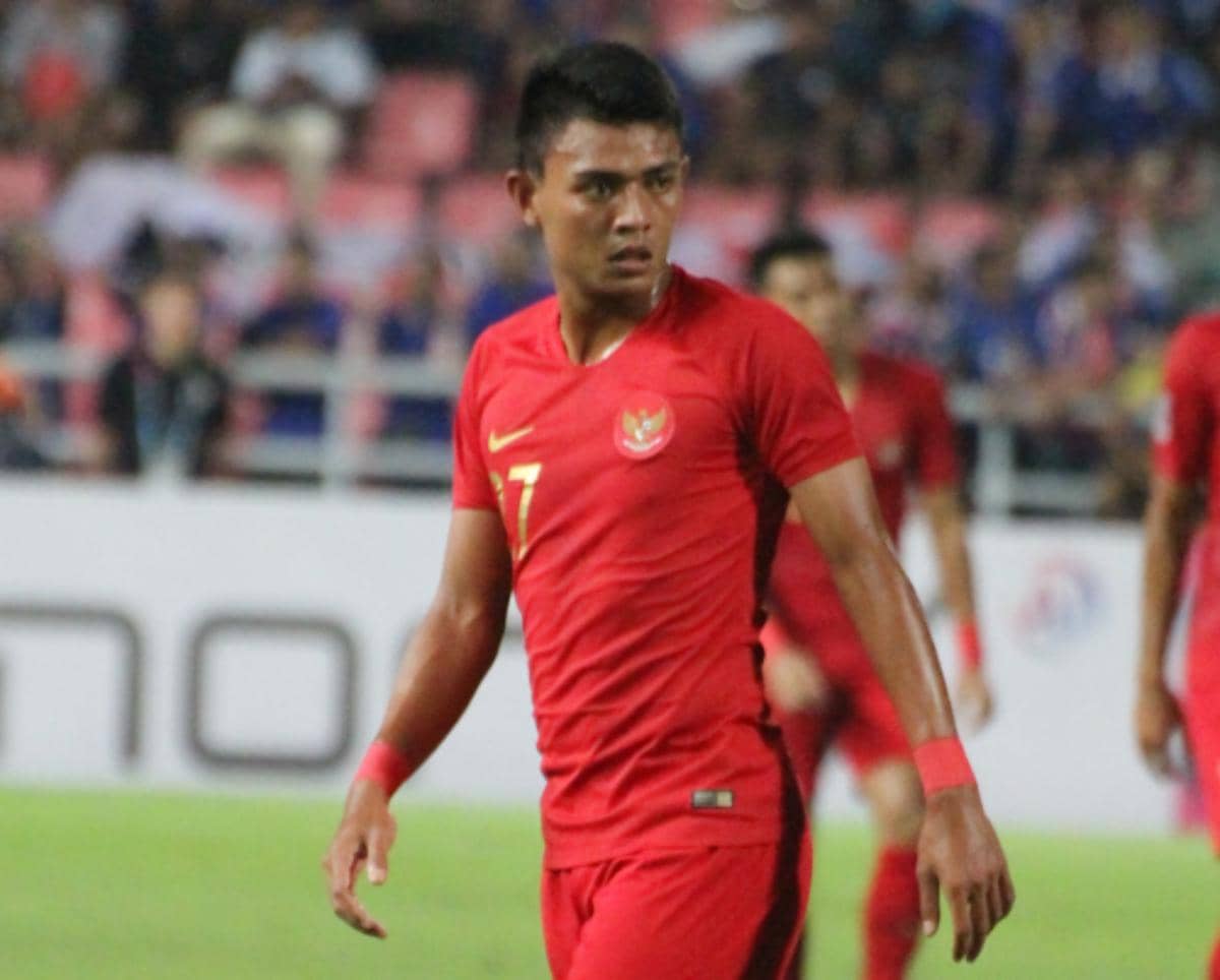 Seorang pemain sepak bola mengenakan seragam merah tim nasional Indonesia dengan nomor punggung 7 di lapangan pertandingan.