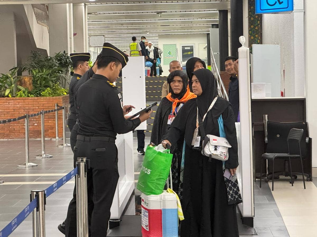 Petugas imigrasi memeriksa dokumen jemaah haji yang baru tiba di Bandara Soekarno-Hatta dengan membawa barang bawaan mereka.