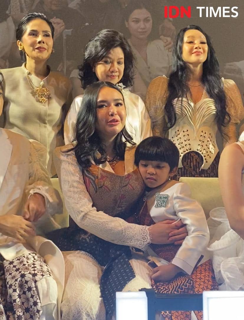 Seorang aktris mengenakan kebaya duduk sambil memeluk anak kecil di acara premier film Jangan Buang Ibu di XXI Plaza Indonesia.