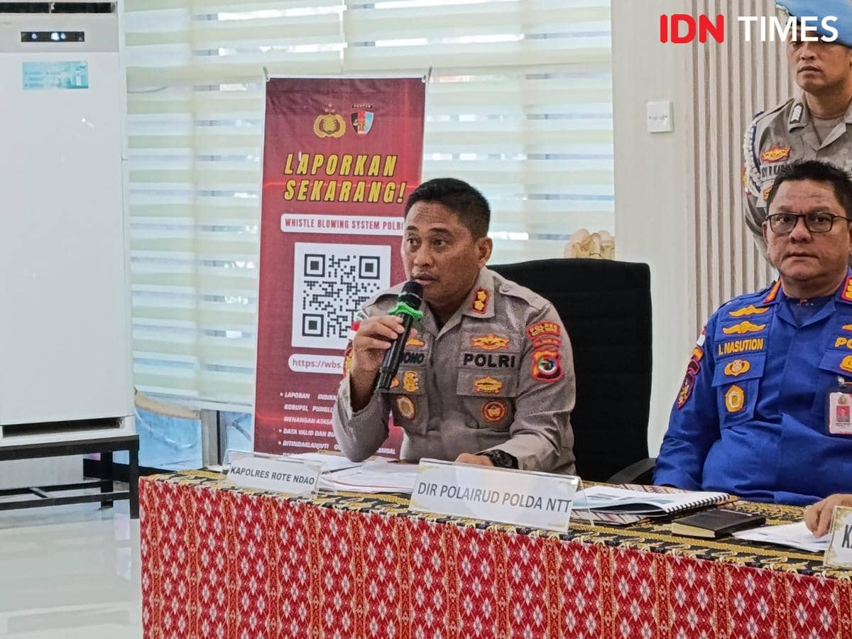 Kapolres Rote Ndao berbicara menggunakan mikrofon dalam rapat bersama pejabat kepolisian di ruangan dengan latar spanduk pelaporan Polri.
