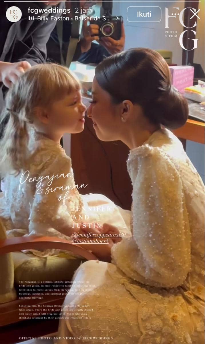 Seorang perempuan mengenakan kebaya putih berhias manik sedang menyentuh hidung dengan anak kecil bergaun senada di acara pengajian jelang pernikahan.