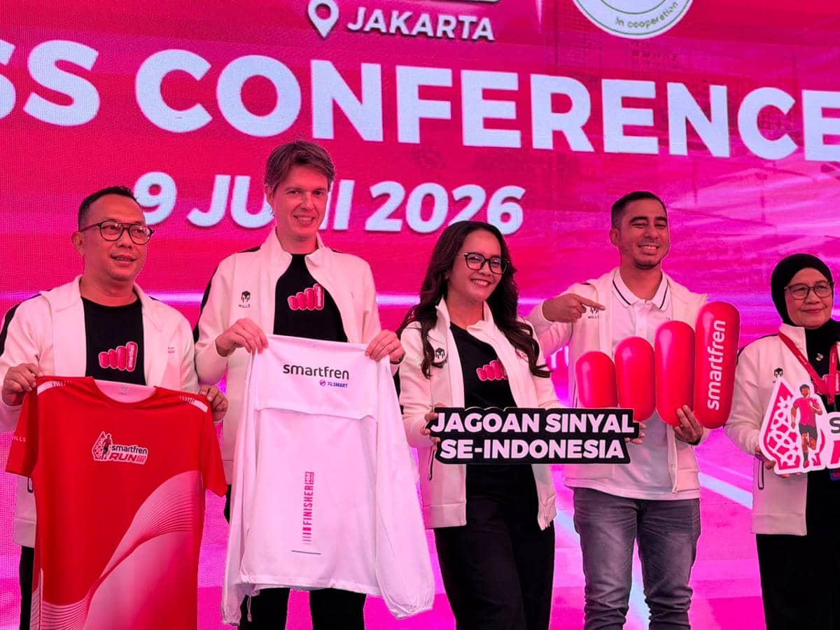 Perwakilan Mills dan Smartfren berpose bersama memegang kaus dan atribut promosi dalam konferensi pers Smartfren Run 2026 di Jakarta.