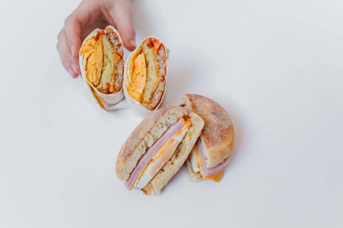 Ilustrasi katsusando, sandwich Jepang dengan isian daging goreng berlapis tepung di antara irisan roti tawar.