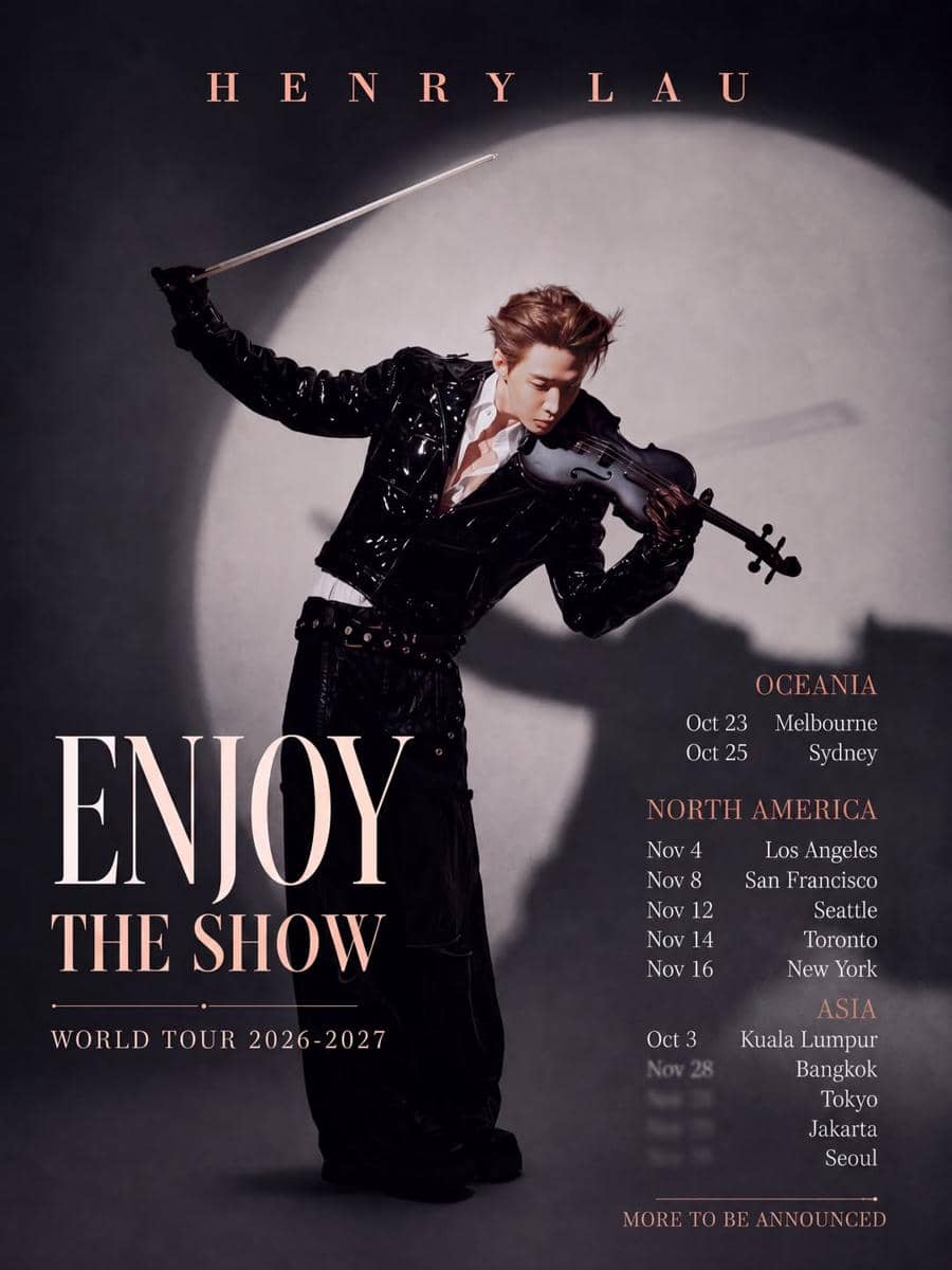 Seorang musisi mengenakan jaket hitam memainkan biola di bawah sorotan lampu dengan teks tur dunia Enjoy The Show 2026–2027.
