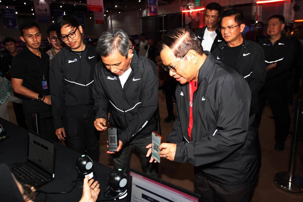 Beberapa pejabat mengenakan jaket hitam memindai kode QR menggunakan ponsel saat meninjau kesiapan acara BTN JAKIM 2026 di Jakarta.