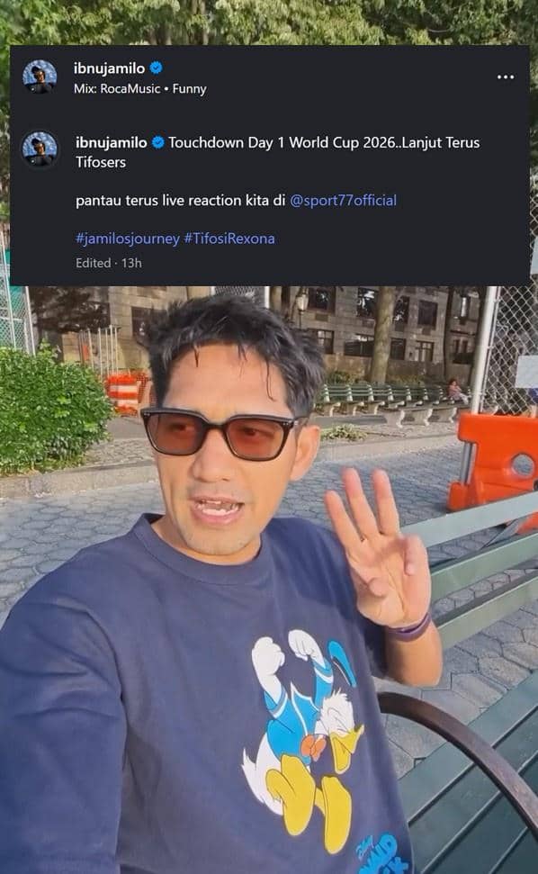 Seorang pria mengenakan kacamata hitam dan kaus bergambar Donald Duck duduk di bangku taman sambil mengangkat tiga jari saat berada di Amerika Serikat.