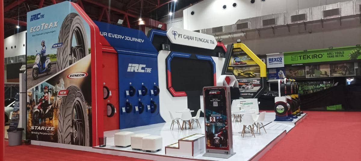 Booth PT Gajah Tunggal Tbk menampilkan produk ban IRC Tire dan Zeneos dengan desain modern di area pameran otomotif.