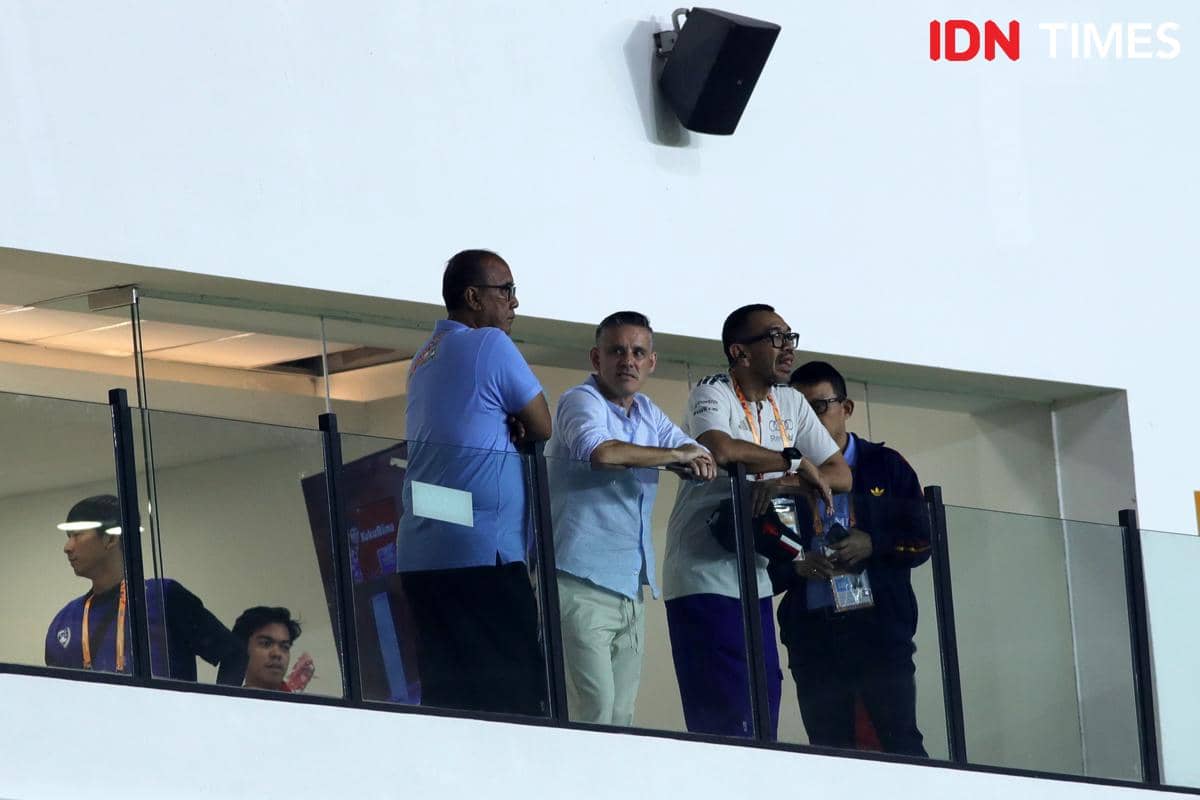 Sejumlah pria berdiri di area tribun atas Stadion Utama Sumut, mengenakan pakaian kasual sambil memperhatikan pertandingan di bawah.