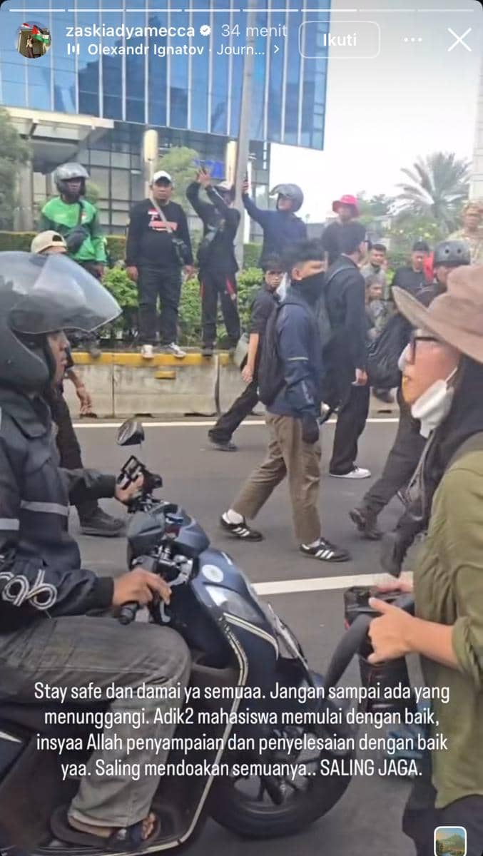 Sejumlah orang berjalan dan berkumpul di kawasan Bundaran HI saat aksi demonstrasi, dengan pengendara motor melintas di jalan.