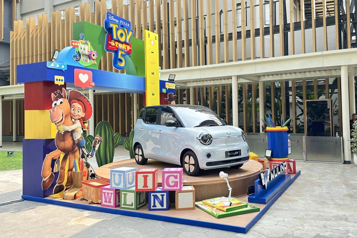 Mobil listrik Wuling Air EV dipamerkan dalam dekorasi bertema Toy Story 5 dengan karakter animasi dan balok warna-warni di sekitarnya.