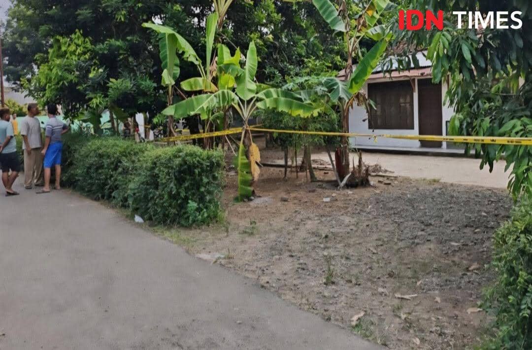 Rumah di Patikraja, Banyumas, dipasangi garis polisi dengan beberapa warga berdiri di dekat lokasi yang dikelilingi pepohonan.