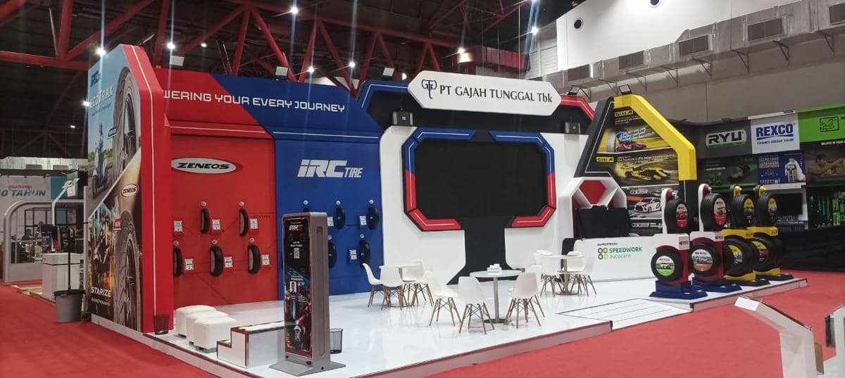 Booth PT Gajah Tunggal Tbk di JFK 2026 menampilkan berbagai produk ban Zeneos dan IRC dengan desain modern dan area duduk pengunjung.