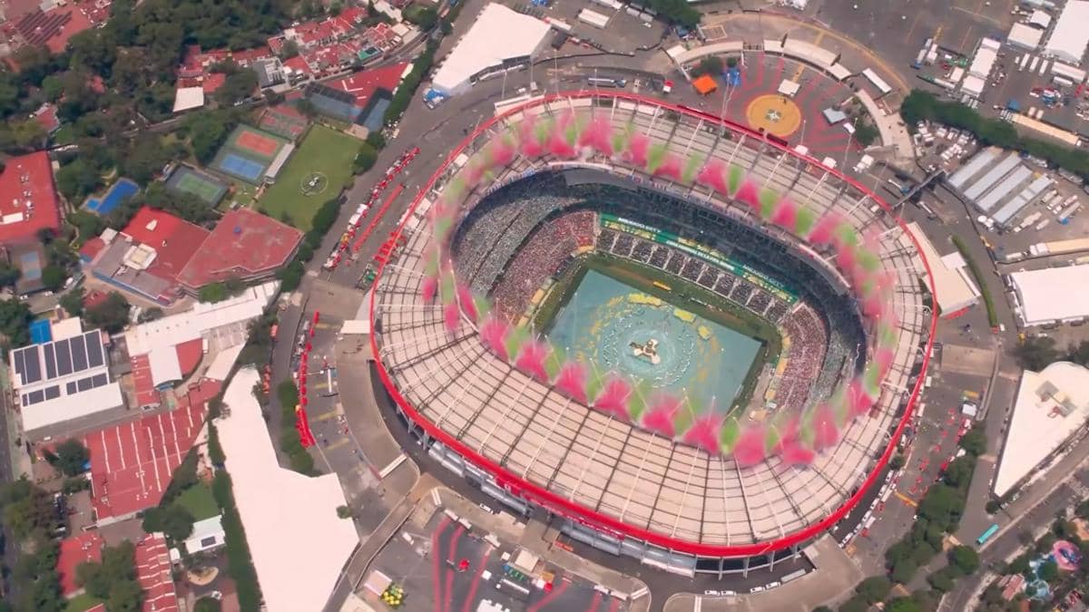 Pemandangan udara stadion besar penuh penonton dengan pertunjukan warna dan kembang asap merah muda serta hijau di upacara pembukaan Piala Dunia 2026.