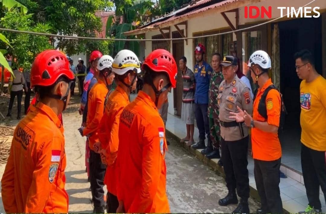 Petugas SAR dan polisi berdiskusi di halaman rumah warga Banyumas saat penyelidikan kasus yang menewaskan dua orang.