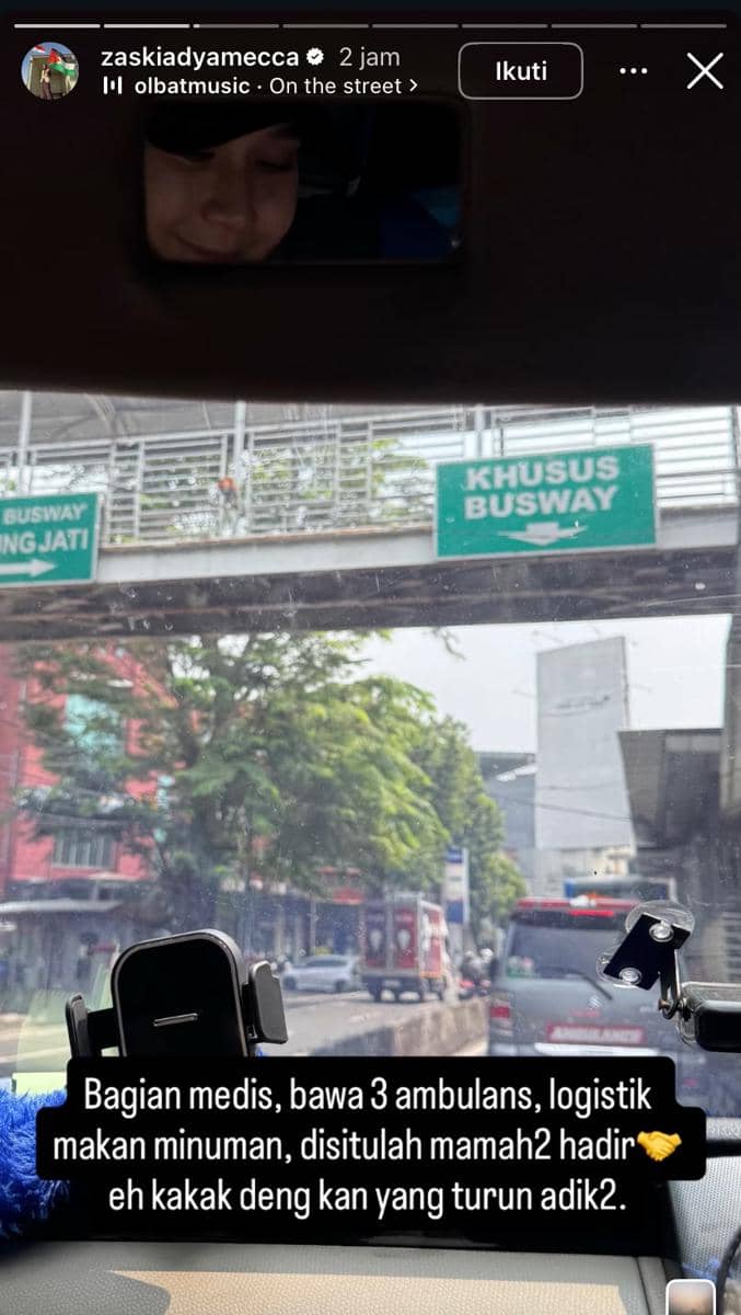 Seorang perempuan berada di dalam mobil dengan pemandangan jalan menuju jalur khusus busway di kawasan Jakarta, terlihat papan penunjuk arah dan lalu lintas padat.
